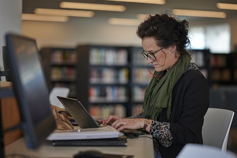 Woman working on laptop in library