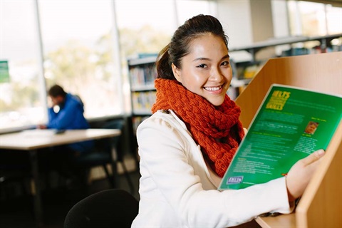 Woman reading a textbook in the library