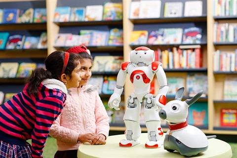Two little girls talk to robot NAO