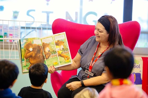 Woman reads a story to a group of children